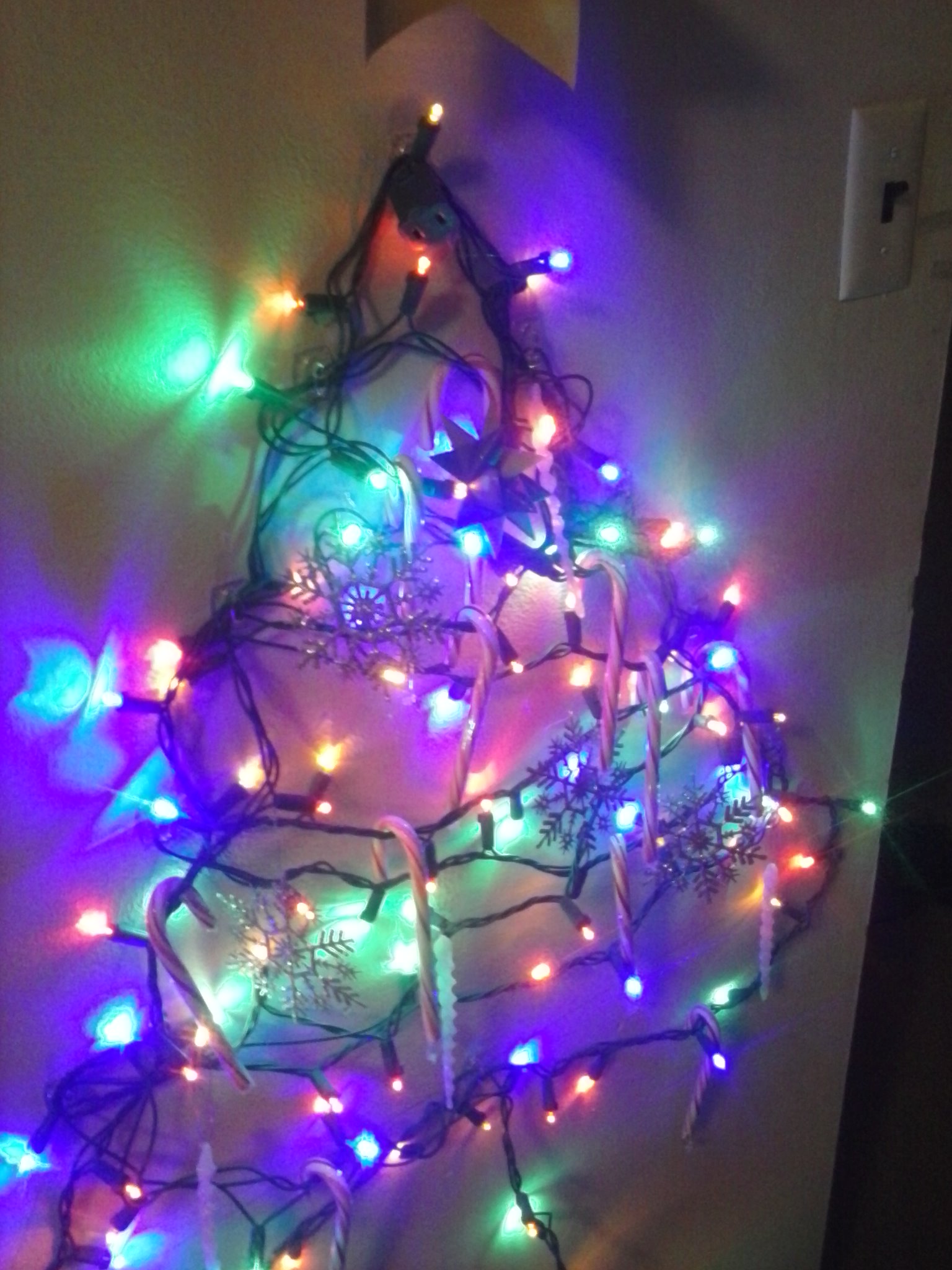 Wall mounted Christmas tree lit up.